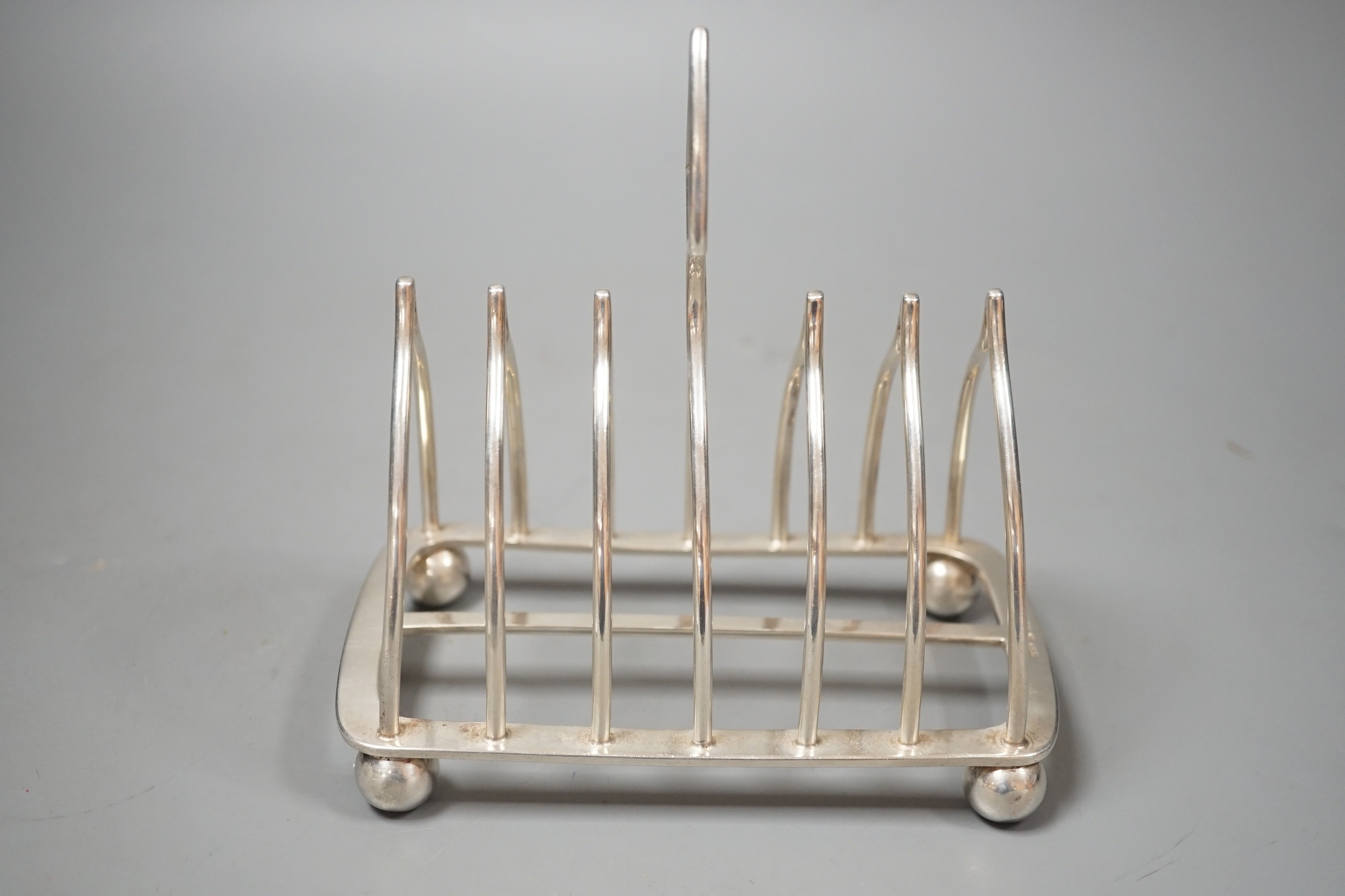 An Edwardian silver eight bar toast rack, on ball feet, by Elkington & Co, Birmingham, 1902, length 15.4cm, 10oz.